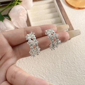 Elegant C-shaped silver stud earrings with irregular crushed silver texture on jewelry box