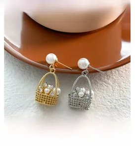 Macro shot of elegant basket-shaped earrings with pearls and crystals on ceramic