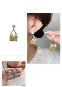Detail of elegant basket-shaped earrings with pearls and rhinestones on a female model