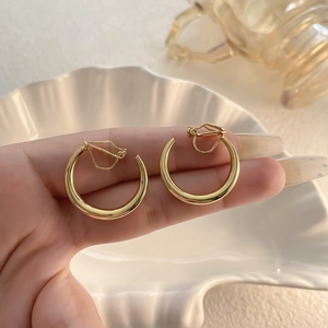 Elegante goldene Clip-Ohrringe in Ringform mit einer glatten, spiegelpolierten Oberfläche