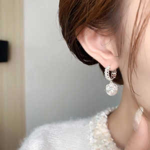 Nahaufnahme eleganter Spitzen-Silberohrringe mit Perlen und Zirkonia am Model
