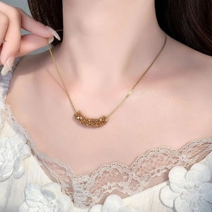 Detail of luxury gold crescent pendant with zircon stones on female neckline