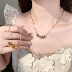 Detailed view of luxury crescent pendants with micro-zirconia in gold and silver finish