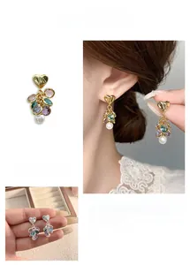 Detail view of heart-shaped earrings with colorful zirconia beads and white pearl drops