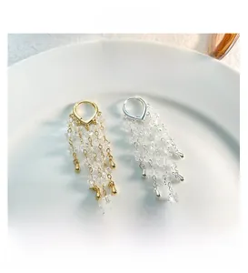 Detail of layered tassel earrings with gold and silver plating and clear crystal beads