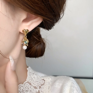 Close-up of luxury heart-shaped gold earrings with colorful zircon tassels and pearls