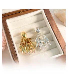 Détail de boucles d'oreilles pampilles feuilles or 18K et argent avec zircons brillants
