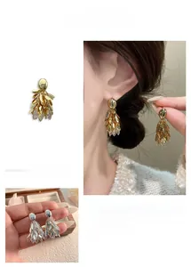 Vue détaillée de boucles d'oreilles feuilles dorées 18K avec zircons scintillants
