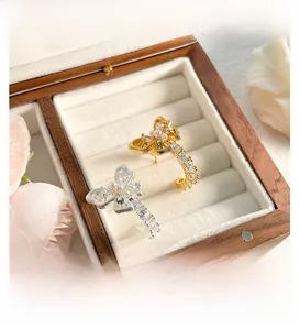 Detail view of gold and silver butterfly pearl earrings with delicate hollow design