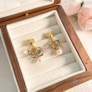 Detail of luxury heart earrings with colorful zircon and pearl in a jewelry box