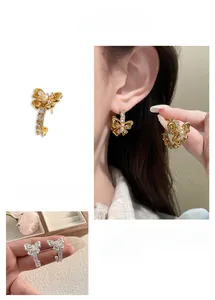Macro detail of butterfly earrings with pearls and crystals in gold and silver finish