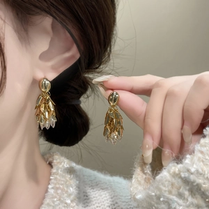 Boucles d'oreilles feuilles dorées 18 carats avec cristaux de zircon sur mannequin