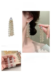 Close-up of dangling rhinestone tassel earrings with marquise-cut crystal and gold-tone base