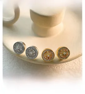 Close-up of sparkling round starburst earrings with zircon inlay in gold and silver