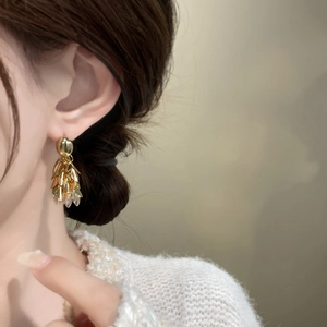 Détail de boucles d'oreilles feuilles à franges en cuivre plaqué or 18 carats et zircon