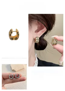 Detailed view of U-shaped huggie earrings with pave leopard pattern cubic zirconia