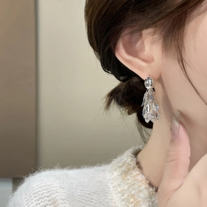 Détail des boucles d'oreilles à pompons en feuilles avec placage or 18K et zircons