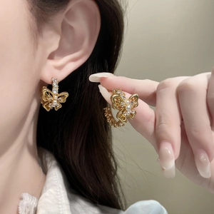 Exquisite gold double-layered butterfly earrings with white pearls and zircons on ear