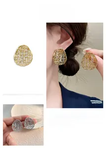 Detail of 18k gold plated hollow mesh earrings with zircon on model and in hand