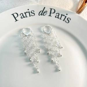 Close-up of silver long tassel earrings with clear beads and water drop pendants