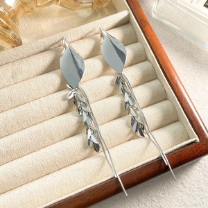 Detailed view of silver wheat ear tassel earrings in a velvet jewelry box