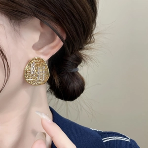 Macro detail of 18k gold plated hollow oval earrings set with sparkling cubic zirconia