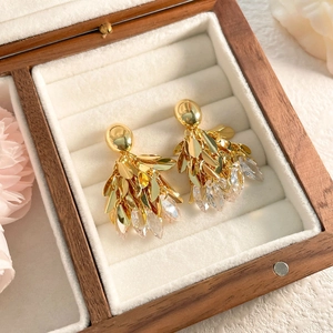 Détail de boucles d'oreilles feuilles à pampilles dorées 18K avec cristaux de zircon