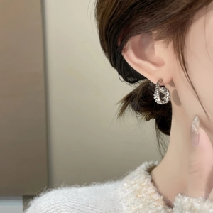 Detail of 18K gold-plated zircon earring worn by model showing intricate pave setting