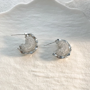 Detail of silver irregular wavy earrings with intricate woven mesh hollow design