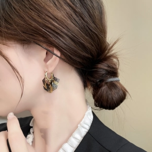 Detailed close-up of layered ginkgo leaf earrings with vintage gold and bronze metallic finish