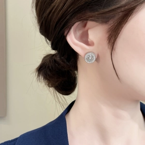 Close-up of sparkling starburst stud earrings with pavé zircons on model ear