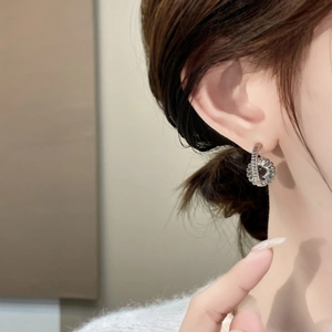 Exquisite 18K gold plated interlocking zircon stud earrings worn on a model