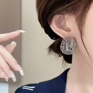 Silver hollow mesh oval stud earrings with glittering cubic zirconia on female model