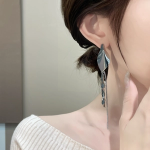 Close-up of vintage silver wheat tassel earrings on model showing metal texture