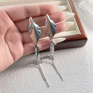 Detail of silver leaf earrings with long tassel snake chains and shimmering sequins