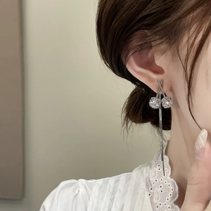 Vista detallada de los pendientes de trébol de plata con cristales en una modelo