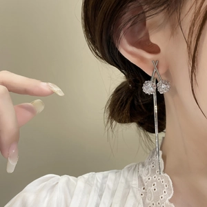 Elegantes pendientes plateados de borlas con flores de cristal usados por la modelo