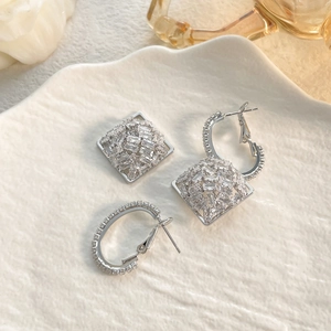 Detailed view of silver geometric earrings with pavé set rectangular cubic zirconia