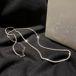 Elegant silver shimmering star necklace on black fabric with minimalist lighting
