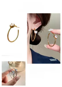 Detailed view of large C-shaped hoop earrings featuring heart-cut sparkling zircon accents