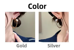 Detail view of gold and silver hoop earrings with heart-shaped cubic zirconia on model