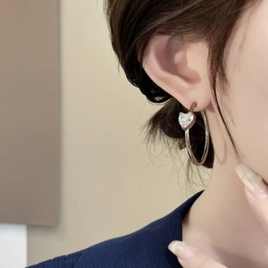 Sparkling heart-shaped zircon silver hoop earrings shown on model for women