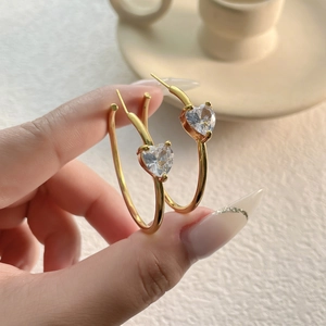 Elegant gold heart zircon hoop earrings featuring large round loops and crystal charms