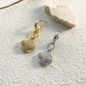 Detailed close-up of gold and silver clover earrings with micro-paved cubic zirconia gems