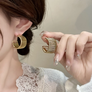 Elegant gold-plated woven texture C-shaped hoop earrings for women shown on model