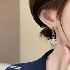 Silver interlocking hoop earrings with micro-pave zircon charms on a model