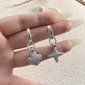 Detailed close-up of asymmetric silver moon and star earrings with pavé zircon