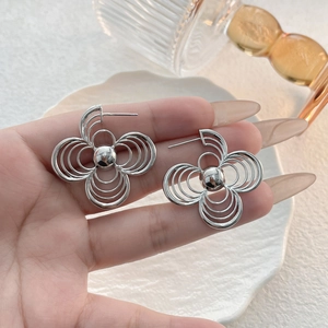 Detailed view of silver hollow floral earrings with multi-layered wire petals design