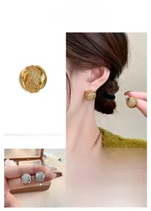 Vue détaillée des boucles d'oreilles nœuds en or et argent avec texture maillée