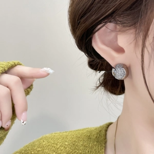 Boucles d'oreilles sphériques argentées avec zircone sur mannequin pour la mode d'automne